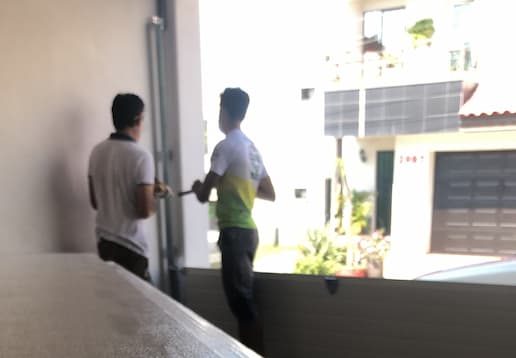 Dos personas instalando un portón americano.